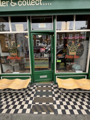 Glass door with green frame. Push silver metal handle on right to open.