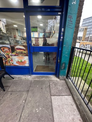 Facing straight ahead to front glass door. Push handle on left to open.