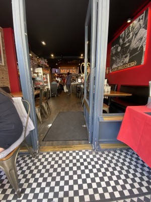 Glass door with wooden frame ahead. Push from metal handle on left to open