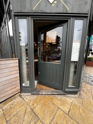 Grey wooden door with glass panel. Push from left to open.