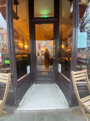 Preceding archway, then main door. Single brown door with glass panel. Push from right to open.