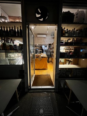 Glass door with white frame. Push from right to open.