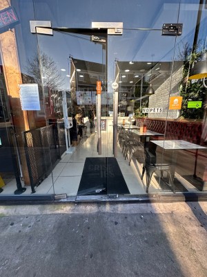 Glass doors with silver handles in middle. Push to open.