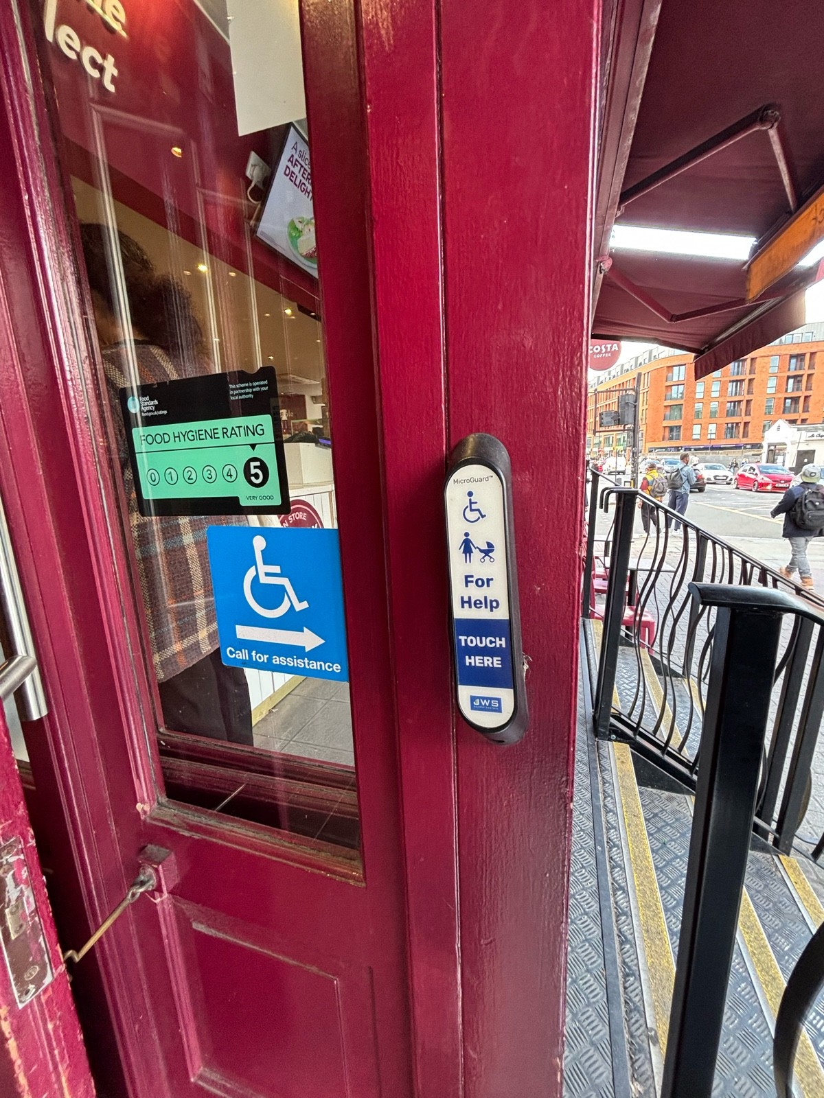 Doorbell for assistance on the right of archway.