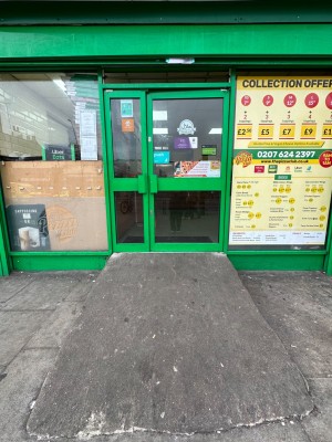Glass doors with green doorframe. Push from left handle of the right door to open.