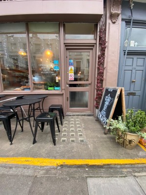 1 step, then path leads straight to door. Outdoor seating to left of path.