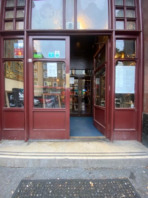 Red doors with glass panels. Push from middle to open.