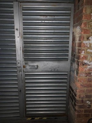Steel door. Handle on left. Pull to open.