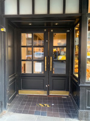 Black framed glass doors. Pull golden handles in centre to open.