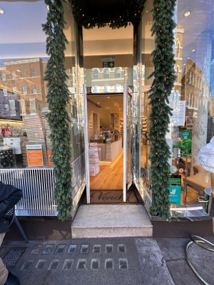Glass door with white frame. Pull silver handles in centre to open.