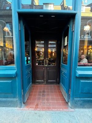 Built-in ramp going up to blue framed glass doors. Push from centre to open.