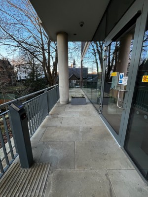 From before main entrance facing left. Reception button on left. Accessible entrance door on right.
