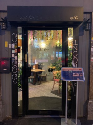 Glass door with black metal frame ahead. Push door from left to open.