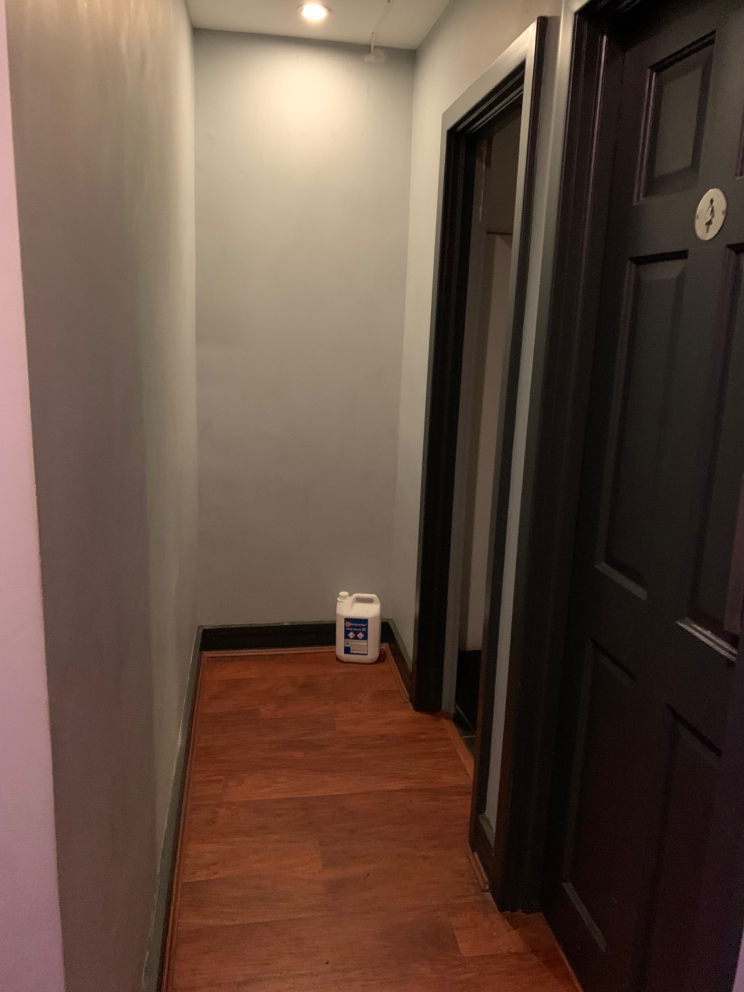 From end of pathway facing left. Toilet doors along right wall. Pathway straight ahead.