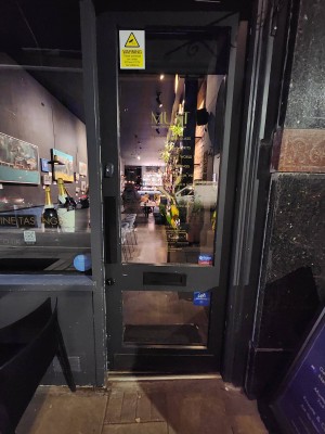 Glass door with black wooden frame. Push from left to open.