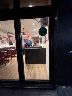 Glass door with black frame ahead. Pull handle from left to open.