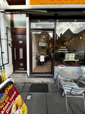 Glass door with dark brown metal frame. Push brown handle on right to open.