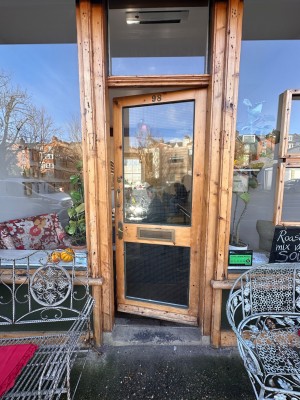 Glass door with wooden frame ahead. Push from left to open.