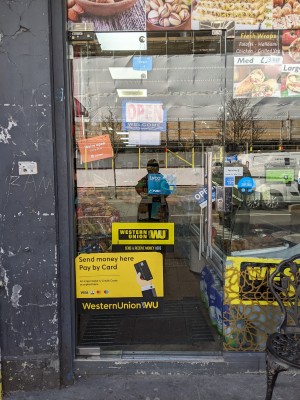 Glass door with metal handle on right. Push to open.