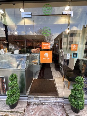 Glass door with metal handle on right. Push to open.