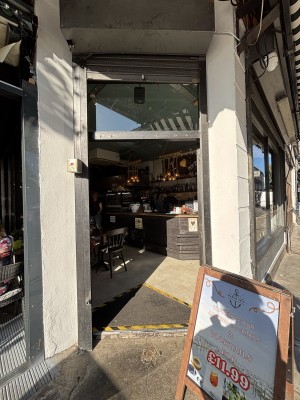 Entrance to venue, double glass doors with black frames, venue sign in bottom right
