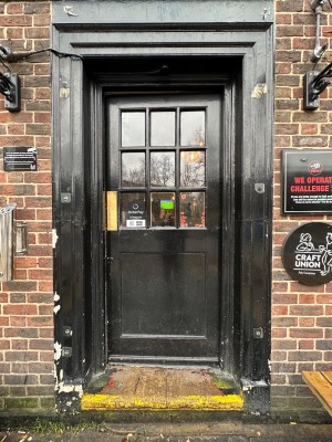 Glass and wood panelled entrance door. Push from left.