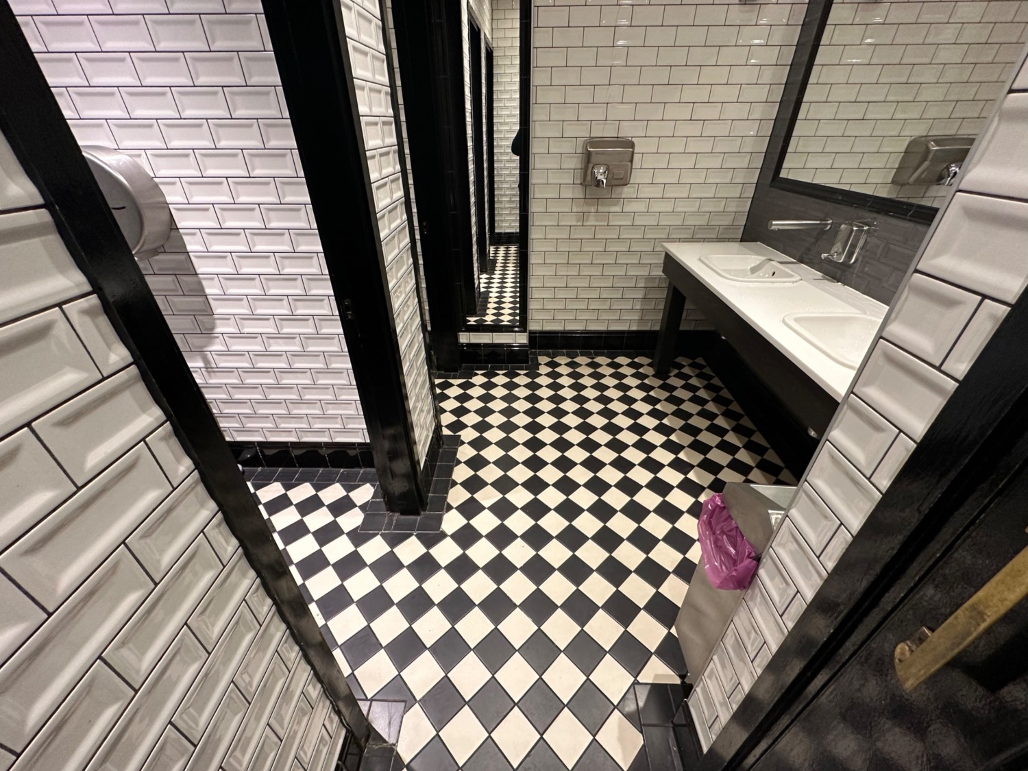 From door facing straight. Sinks along back right. Stall doors along left.