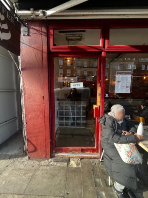 Glass door with red frame. Push handle from right to open.