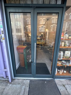 Facing straight ahead towards front double glass doors. Push handle on left of right door to open.