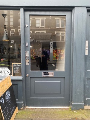 Grey door with glass panel. Push from left to open.