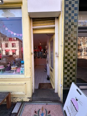 Yellow wooden door with glass panel. Push from left to open.