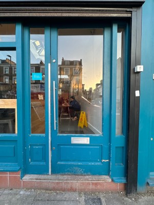 Glass door with blue frame. Push from left.