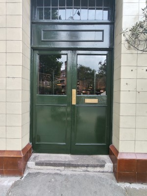Green framed glass doors ahead. Push from centre to open.