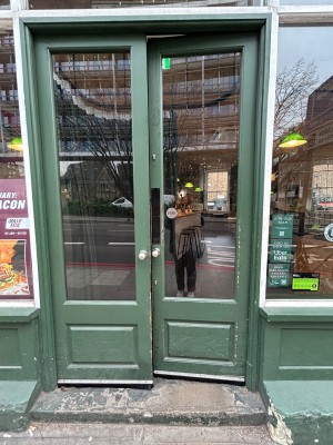 Double green wooden doors with large glass panels. Push from middle to open.