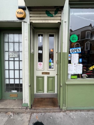 Green and glass panelled door. Push gold handle from right to open.