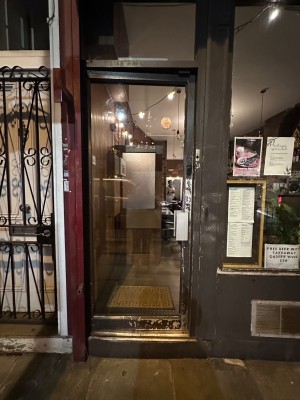 Glass door with black doorframe. Push from right to open