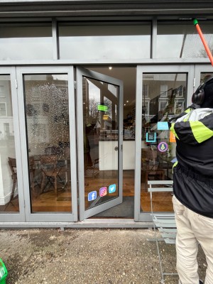 Glass door with grey frame ahead. Push from right to open.