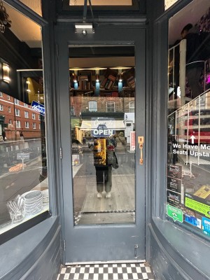 Dark grey wooden door with large glass panel. Pull handle on right to open.
