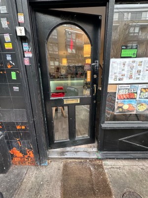 Glass door within black frame. Push handle on right to open.