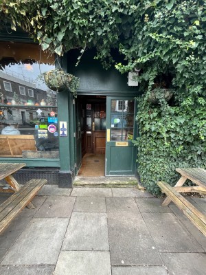 Dark green wooden double doors with glass panel. Push from middle to open.