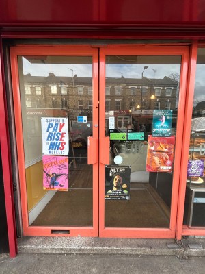 Glass doors with orange frames. Push orange handles in centre to open.
