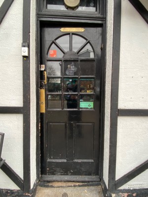 Black door with glass panels. Push from left to open.