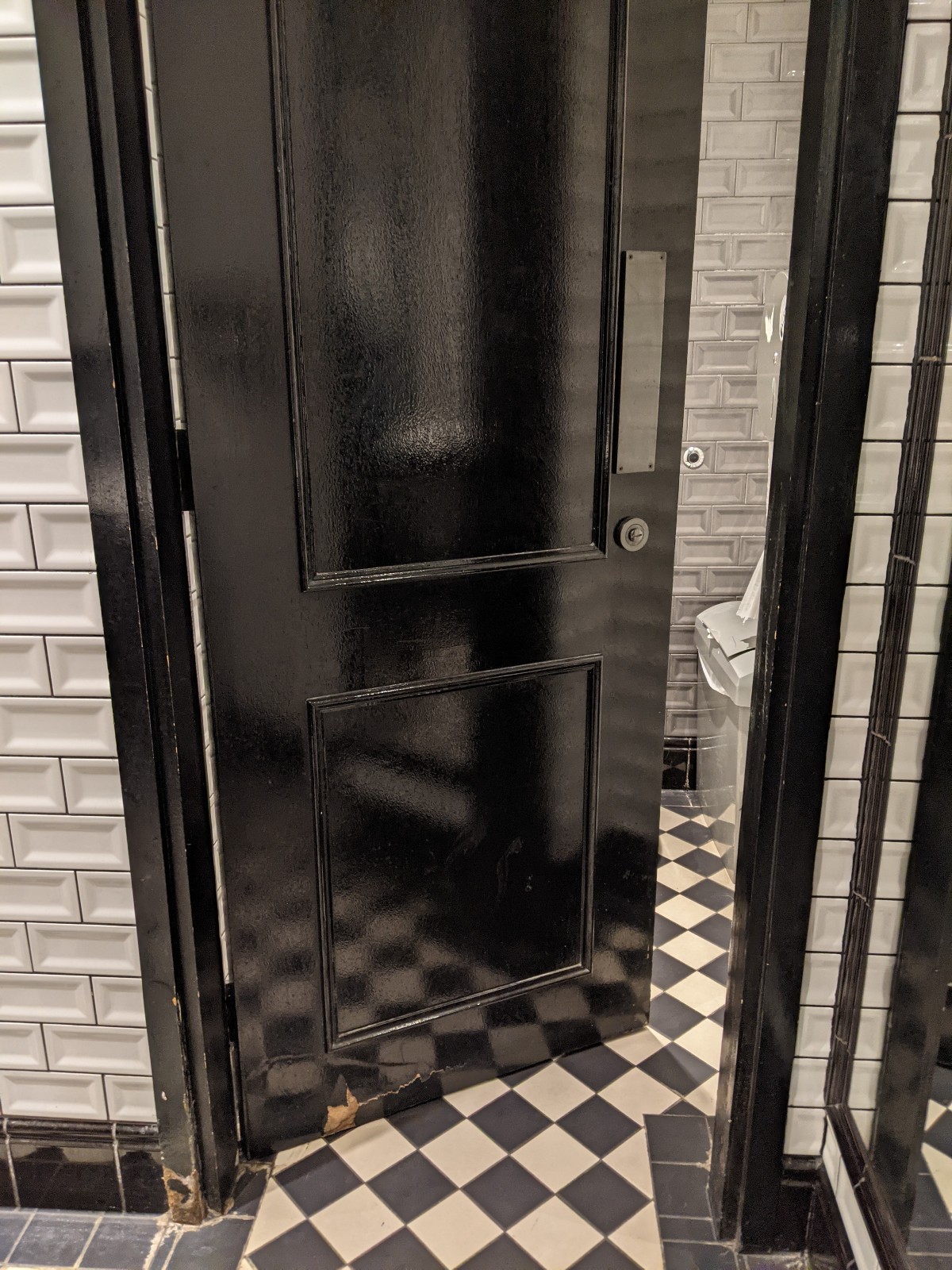 From end of sinks facing left. Black door with white frame ahead. Push from right to open.