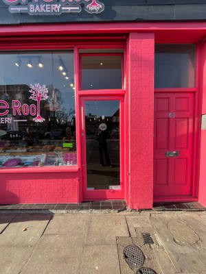 Single glass door outlined in pink. Push from left to open.