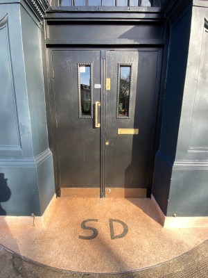 Black double doors with glass panels. Pull from middle to open.
