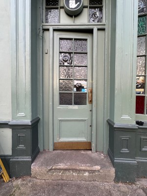 Glass and green wood panelled entrance door. Push from right.