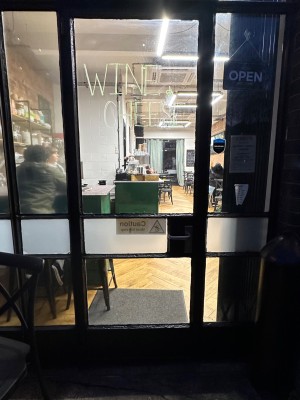 Glass door with black doorframe. Handle at right. Pull to open