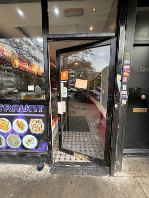 Glass door with black metal frame & silver metal handle. Push from left to open.