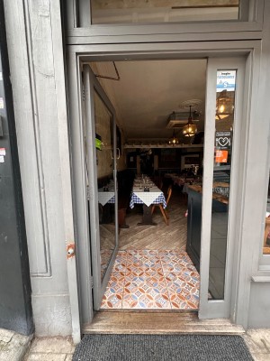 Glass door with grey wooden frame. Push from right to open.