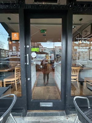 Glass entrance door with grey wooden frame. Push from left.